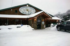 Conneaut Cellar Winery building in Conneaut Lake PA is shown covered in snow as customers enter the gift shop during the holidays.